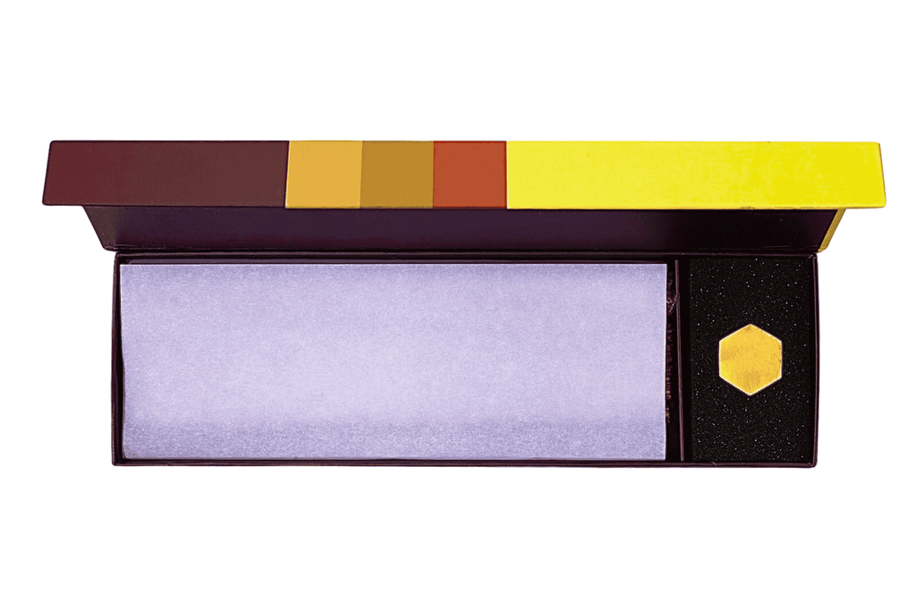 High-resolution photo of the open magnetic click-top box showcasing the neat arrangement of Exotique incense sticks along with brass incense burner.
