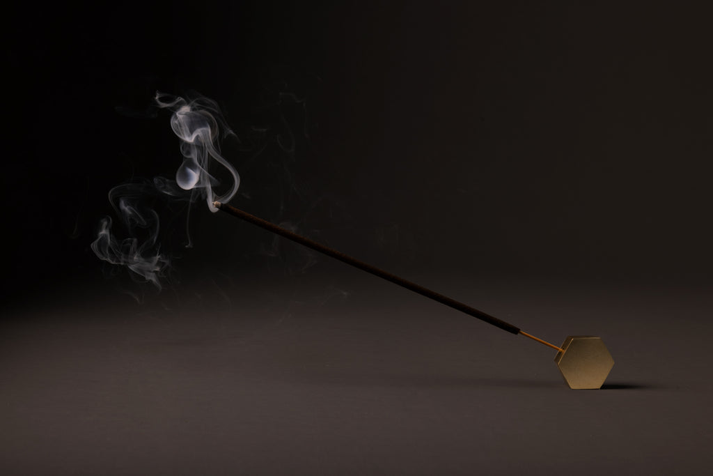 Incense stick with smoke on a dark background